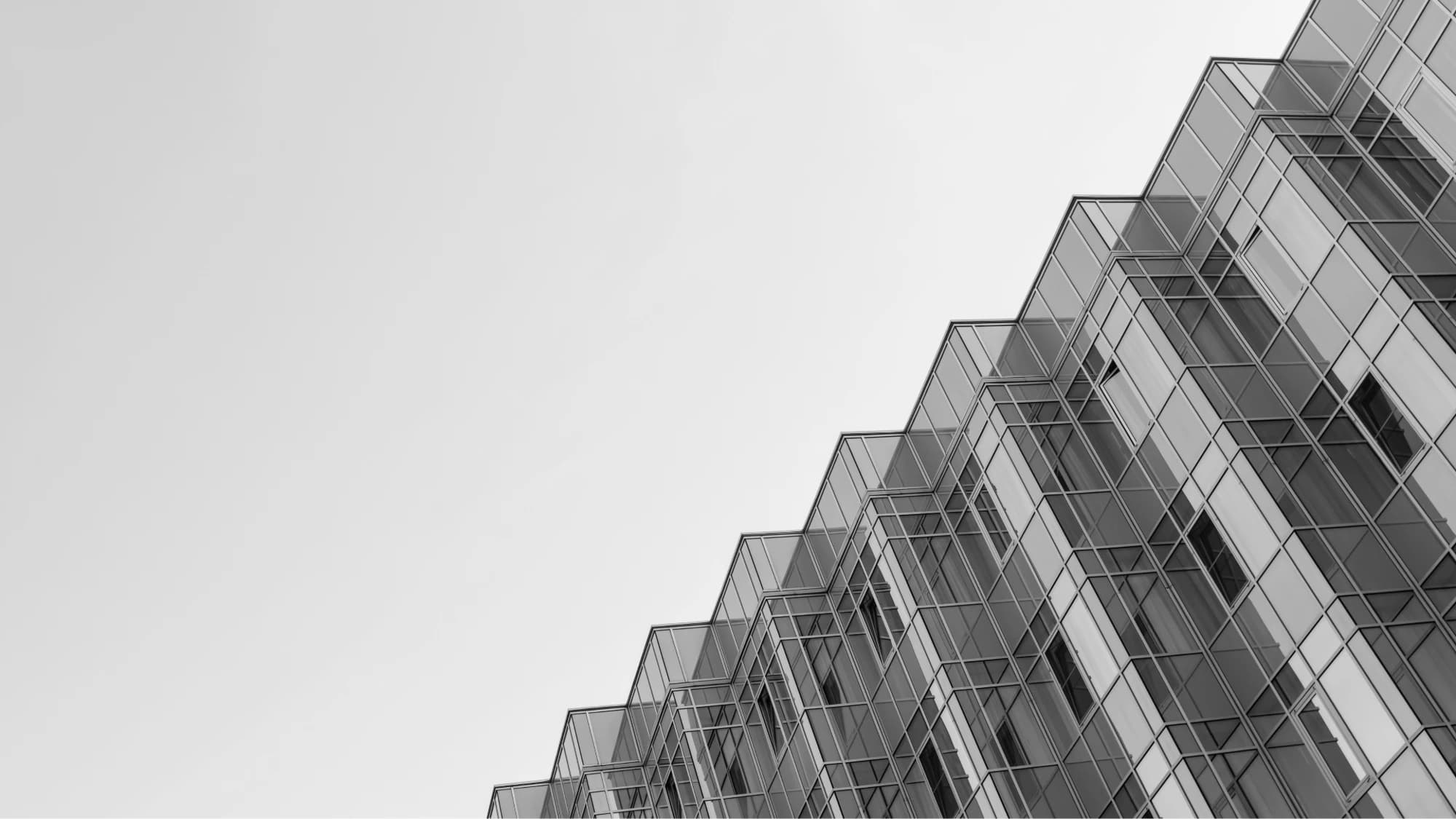 Angular glass building facade seen from below, monochrome